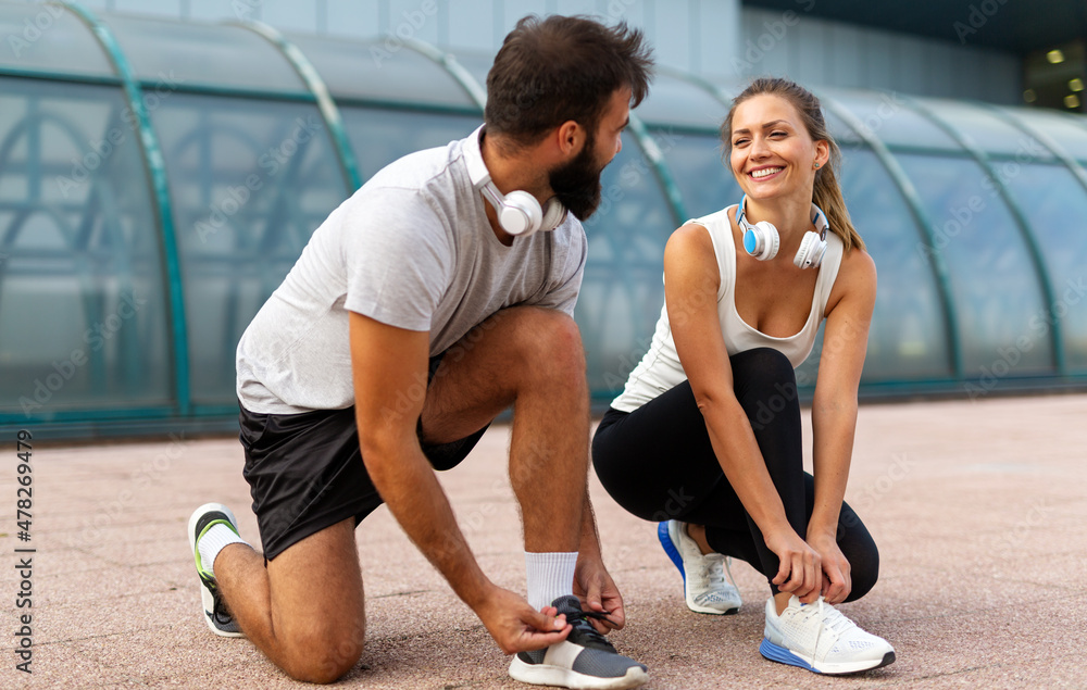 Happy runner couple exercising outside as part of healthy lifestyle. People sport running concept