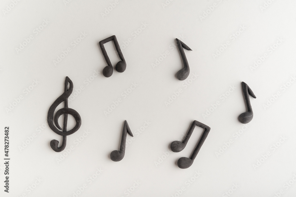 Threedimensional black treble clef and music notes on white background