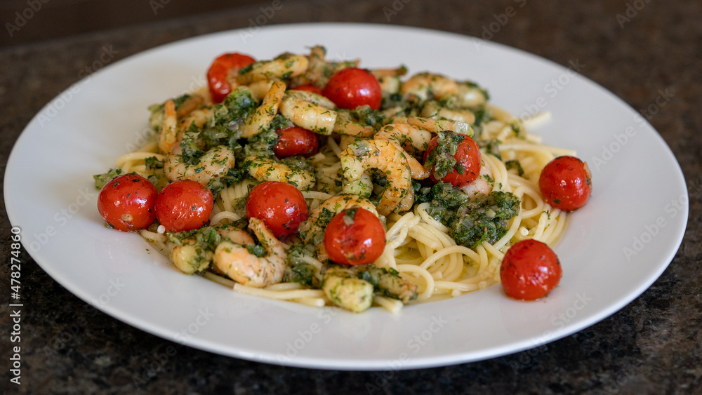 ready to eat - spaghetti with shrimps and cherry tomatoes in olive oil with onions and herbs