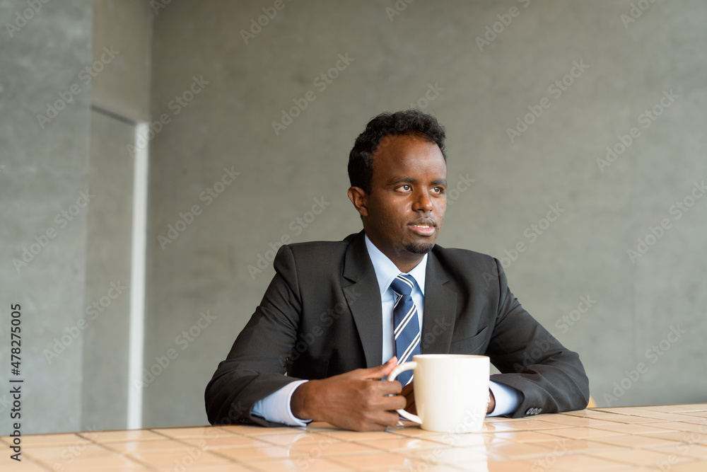 Portrait of African businessman wearing suit and tie in coffee shop Portrait of African businessman wearing suit and tie in coffee shop