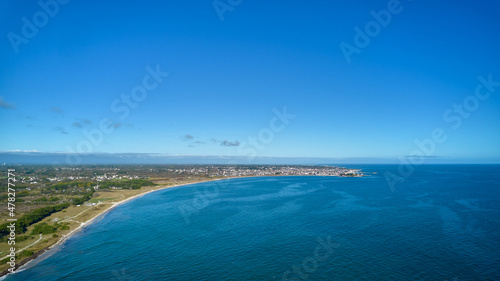 Aerial view of beach in France. City at the top. Blue sea water and sky for text free space. Brittany, Kerfriant, Du Ster.