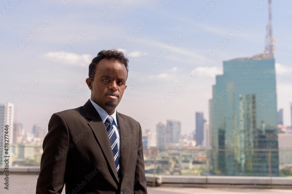 Portrait of African businessman wearing suit and tie outdoors in city