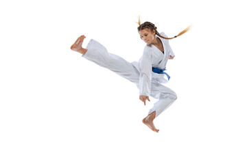 Dynamic portrait of young girl, teen, taekwondo athlete jumping isolated over white background. Concept of sport, education, skills