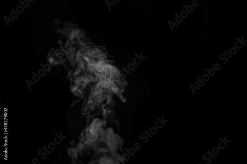 Fragment of white hot curly steam smoke isolated on a black background, close-up. Create mystical photos. © Alena