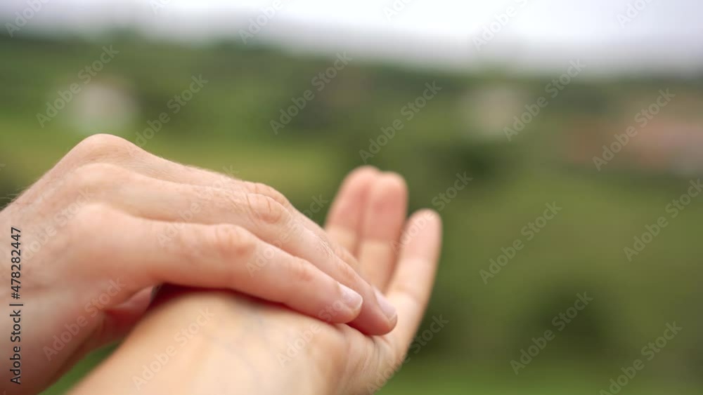 Close up view of unrecognizable couple holding hands on green background. Cropped horizontal view of unrecognizable caucasian people caressing hands. People an emotions concept. Close up view of unrecognizable couple holding hands on green background. Cropped horizontal view of unrecognizable caucasian people caressing hands. People an emotions concept.