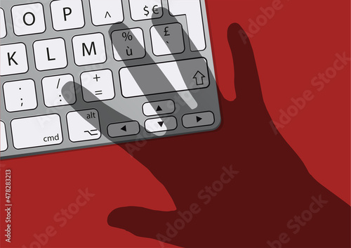 Concept de la sécurité informatique et du risque de piratage de données avec le symbole de l’ombre d’une main qui menace un clavier d’ordinateur.