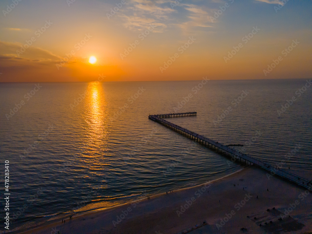 Obraz premium Aerial view of Palanga bridge to the Baltic sea and a sunset in horizon