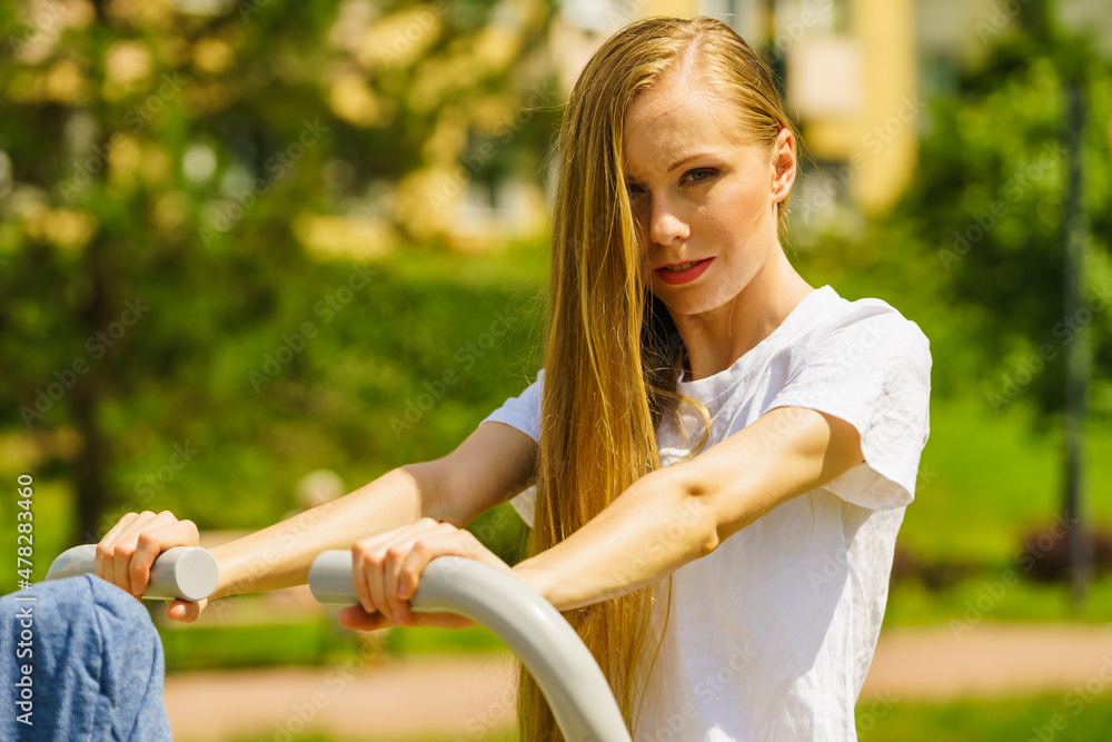 Naklejka premium Female doing exercise in outdoor gym