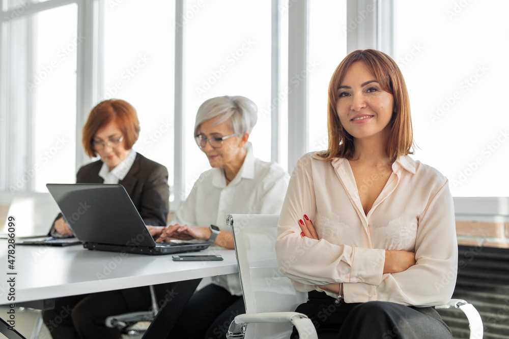 Handshake of successful Caucasian women in the office for a laptop Handshake of successful Caucasian women in the office for a laptop