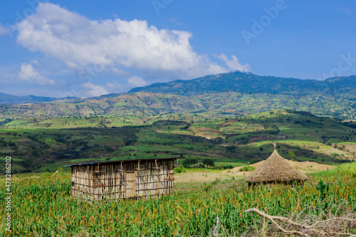 Breathtaking View to the Traditional African Houses, Green Trees and Mountains under Cloudy Blue Sky of the Omo River Valley, Ethiopia