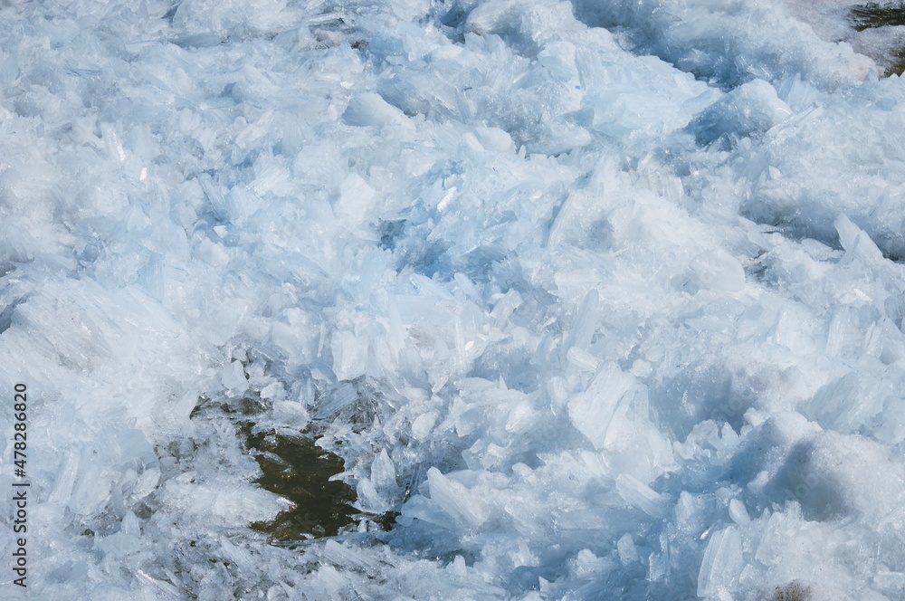 Melting river ice. Columnar and needle-like structure of crystals. Ice floe in the spring on the banks of the Amur River.