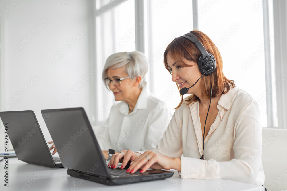Portrait of two adult women professionals at work with laptops Portrait of two adult women professionals at work with laptops