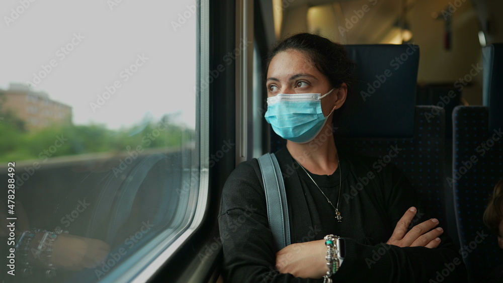 Woman wearing surgical face mask riding train