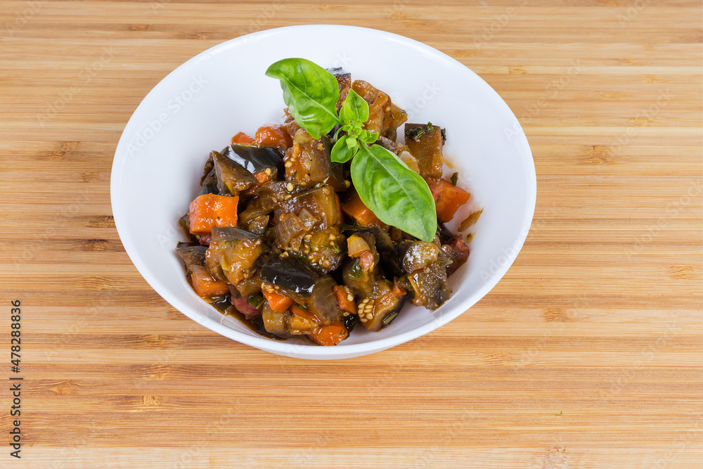 Chopped eggplants stewed with other vegetables in the white bowl Chopped eggplants stewed with other vegetables in the white bowl