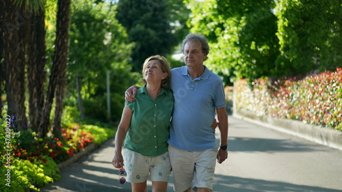 Romantic older couple going for a walk, 60s senior husband and wife together