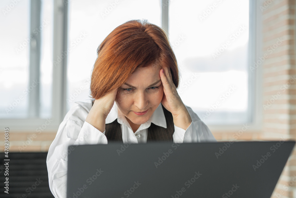 Headache in adult woman sitting with laptop Headache in adult woman sitting with laptop