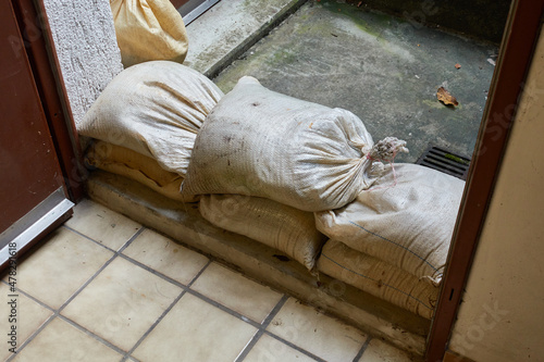 Protective measure against floods in basements. Barrier made of sandbags lies in the entrance area of a residential building. Closeup.