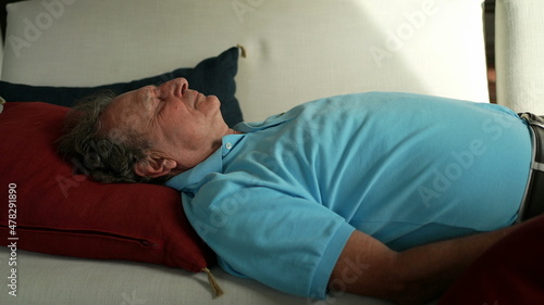 Older man lying in sofa resting. Senior person napping