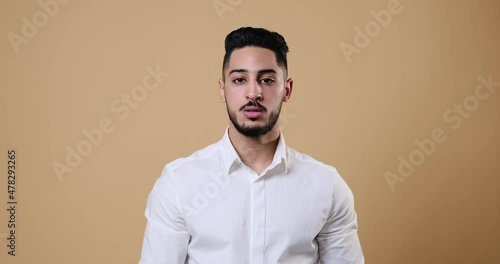 Wallpaper Mural Young businessman gesturing with finger on lips over beige background Torontodigital.ca