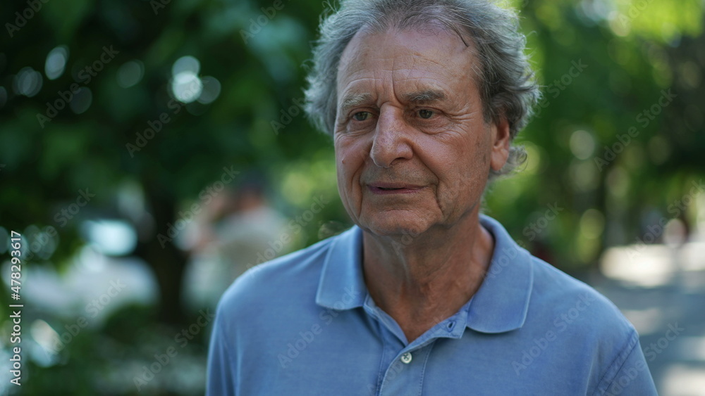 Happy senior man walking forward smiling. One older person walks in green urban city Happy senior man walking forward smiling. One older person walks in green urban city