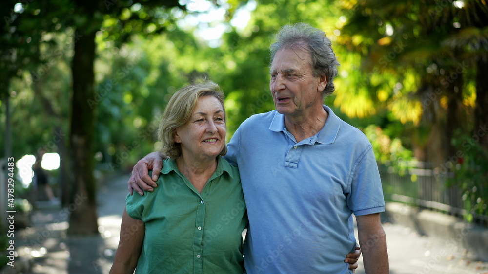 Obraz premium Happy senior couple in 60s walking embracing each other, old age relationship