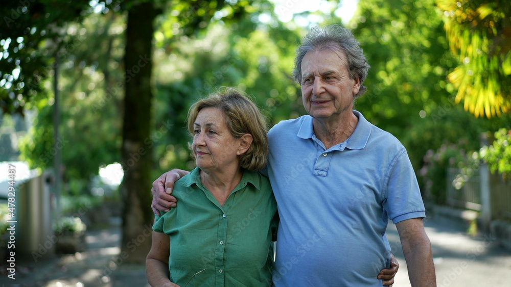 Happy senior couple in 60s walking embracing each other, old age relationship Happy senior couple in 60s walking embracing each other, old age relationship