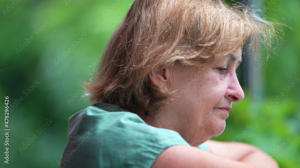 Contemplative older woman looking out from balcony, pensive senior Contemplative older woman looking out from balcony, pensive senior