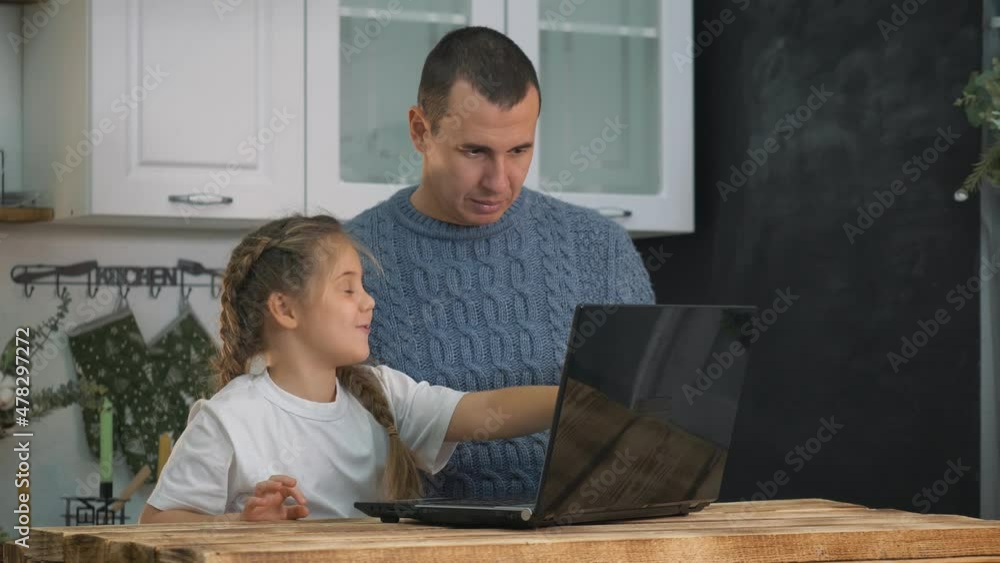 male tutor helps girl to study online at home. Online lesson, webinar, online teacher in application. Help from tutor in teaching child. girl sits with her dad at laptop and does online tasks. male tutor helps girl to study online at home. Online lesson, webinar, online teacher in application. Help from tutor in teaching child. girl sits with her dad at laptop and does online tasks.