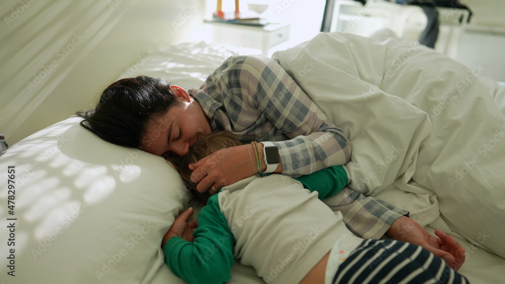 Obraz premium Child and mother affection cuddle in bed together