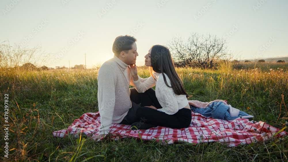 Coppia fa picnic in campagna nella natura al tramonto per san Valentino