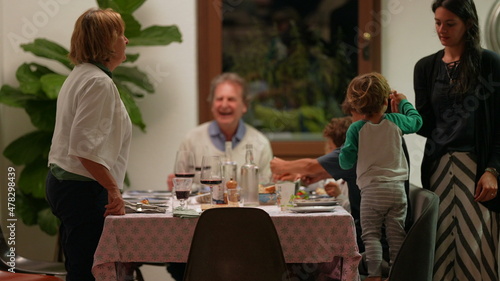 Candid family gathered around table celebrating holidays together