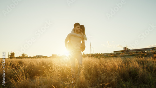 Coppia si abbraccia in un campo giallo al tramonto photo