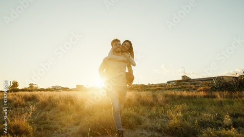 Coppia si abbraccia in un campo giallo al tramonto photo