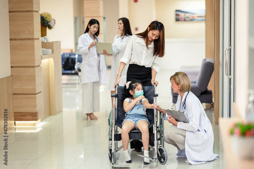 Obraz premium Parents or mothers take their daughters in wheelchairs to a doctor or scientist. to check the body to find the cause of the illness in the hospital