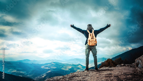 Happy man with open arms standing on the top of mountain - Hiker with backpack celebrating success outdoor - People, success and sport concept © Davide Angelini