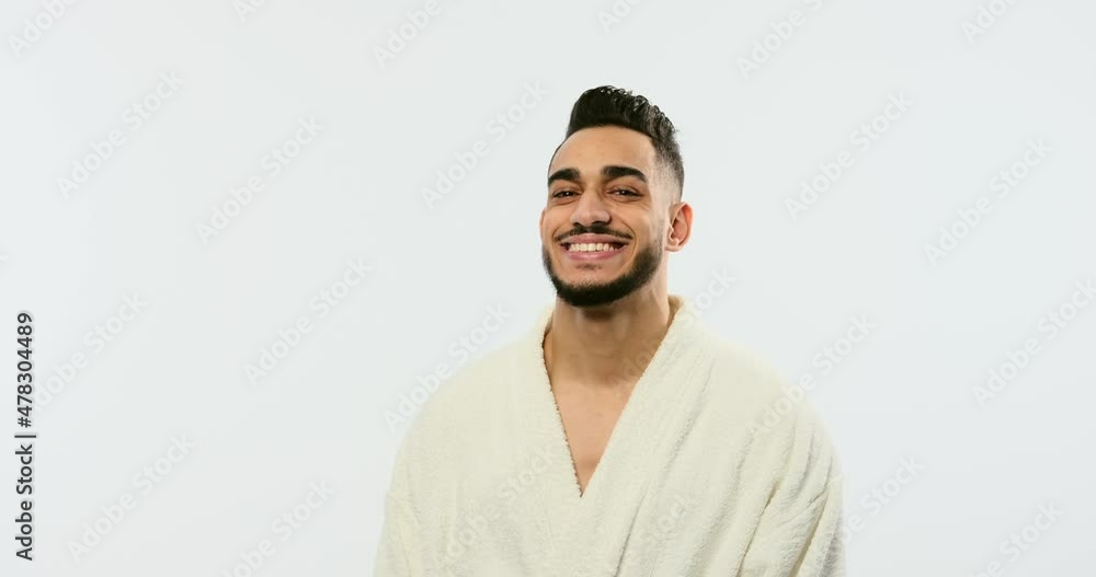 Young man in bathrobe with arms crossed over white background Young man in bathrobe with arms crossed over white background