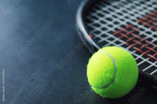 Sport and healthy lifestyle. Tennis. Yellow ball for tennis and a racket on the table. Sports background with tennis concept. © alexkich