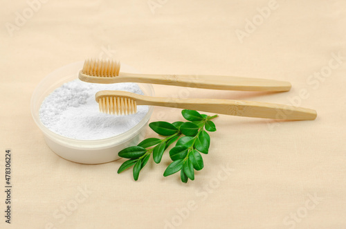 Two wooden toothbrushes and tooth powder on a linen cloth. Dental care with natural ingredients