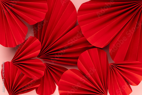 Bright red hearts of folded of chinese paper fans as romantic Valentine day background  texture  closeup  top view.