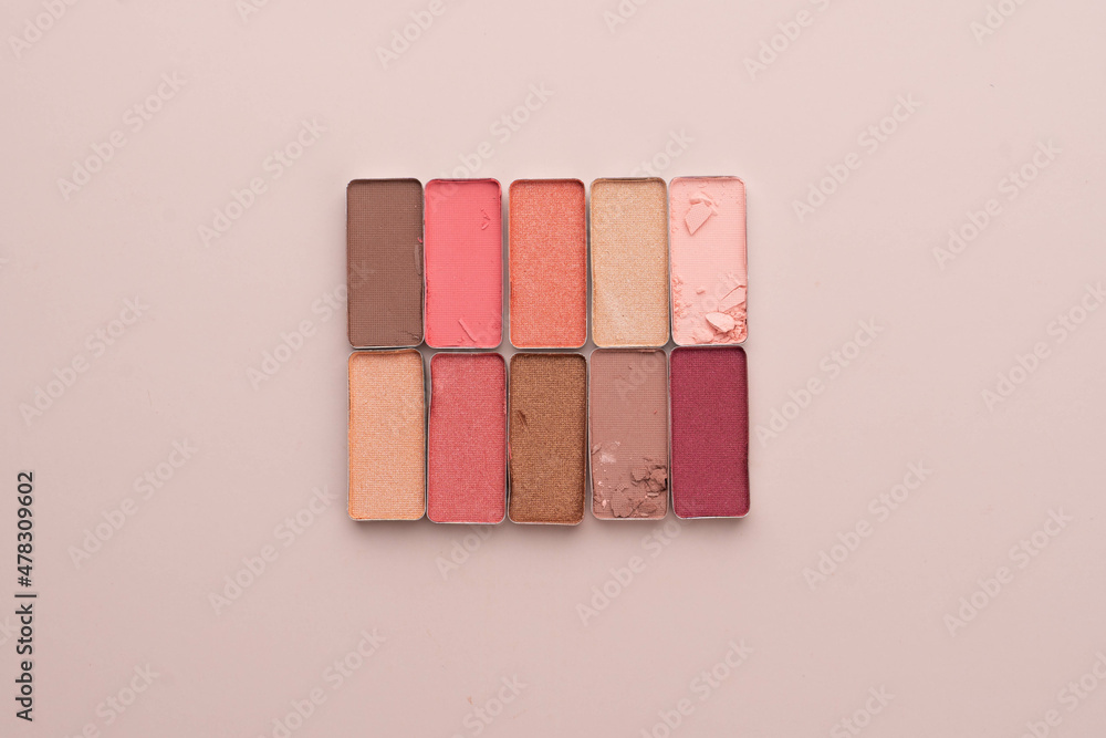 A broken eye shadow make up palette on a beige background. Beauty and cosmetic concept. Flat layout. A broken eye shadow make up palette on a beige background. Beauty and cosmetic concept. Flat layout.