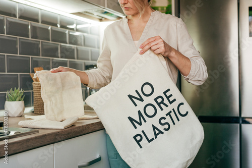 Young woman taking reusable cotton bags for shopping