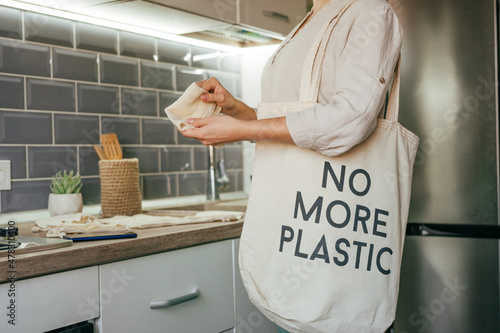 Young woman taking reusable cotton bags for shopping photo