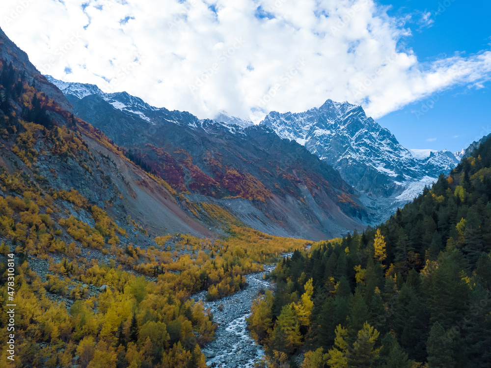 Beautiful, delightful autumn view from a drone of the mountains, the river, the Chalaadi glacier on a sunny day. Very beautiful autumn landscape of the mountains. Fabulous mountain autumn landscape