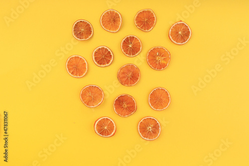 dried sliced orange on a yellow background