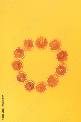 Dried cut orange with a circle on a yellow ground