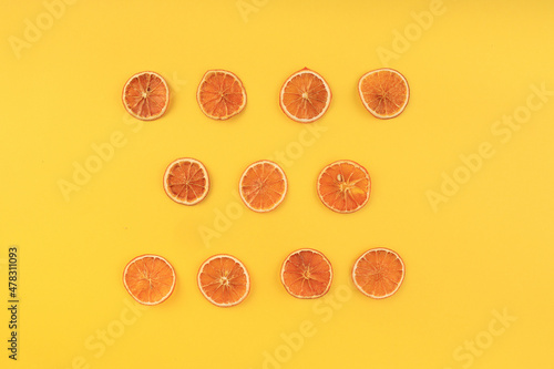 dried slised oranges on a yellow background