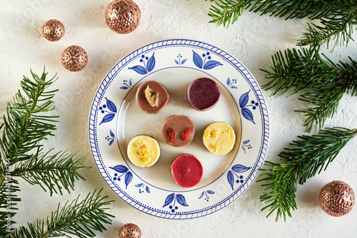 Healthy colorful raw vegan Christmas cookies on a decorated plate, top view