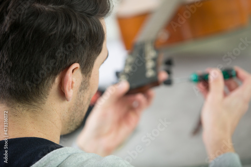 man repairing a guitar