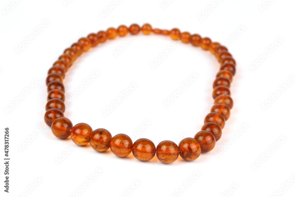 Beautiful necklace of amber beads on a white background Beautiful necklace of amber beads on a white background