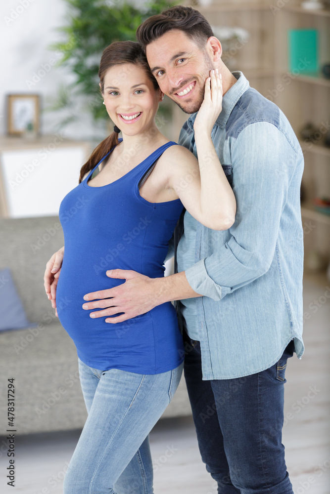 Fototapeta premium handsome man and his beautiful pregnant wife are hugging